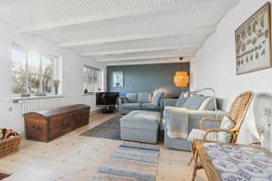 een woonkamer met een bank en een tafel bij Family-Friendly Beachside Holiday Home in Arnager