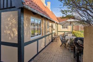 een terras met een tafel en stoelen en een gebouw bij Family-Friendly Beachside Holiday Home in Arnager