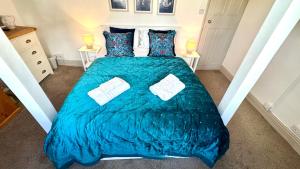 a bedroom with a bed with a blue comforter at Nancie's Place - - A BEAUTIFUL GEORGIAN DUPLEX APARTMENT - - Centre of Old Dartmouth Town - - ONSITE PRIVATE PARKING in Dartmouth