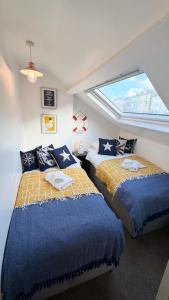 two beds in a room with a window at Nancie's Place - - A BEAUTIFUL GEORGIAN DUPLEX APARTMENT - - Centre of Old Dartmouth Town - - ONSITE PRIVATE PARKING in Dartmouth