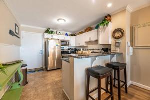 a kitchen with white cabinets and a counter with stools at Perfect Ocean View - Oceanfront Condo, Private Balcony, Community Pool in Kill Devil Hills +22 photos
