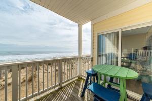 Una mesa y sillas en un balcón con la playa. en Perfect Ocean View - The Sands - K0003A, en Croatan Shores