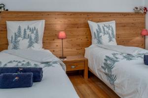ein Schlafzimmer mit zwei Betten und einem Tisch mit Lampe in der Unterkunft Appartements de la Chamoissière in Le Monêtier-les-Bains