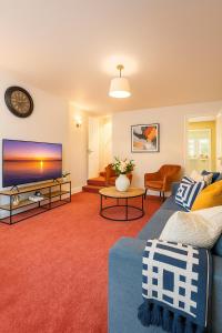 a living room with a blue couch and a tv at Sunnyholme - New! Yorkshire Luxurious Cottage in Hawes