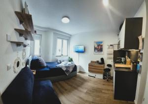 een slaapkamer met een blauw bed en een blauwe bank bij ModernesMiniZimmer-Stadtnah-SelfCheckIn-Parkplatz in Neurenberg