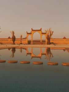 a reflection of a building in a pool of water at Hotel Berber Palace Merzouga in Hassilabied