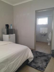 a bedroom with a bed and a bathroom with a toilet at Shalom Villa Guesthouse Walvis in Walvis Bay