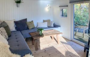 a living room with a blue couch and a wooden table at 3 Bedroom Lovely Home In Skibby in Rønø +15 photos
