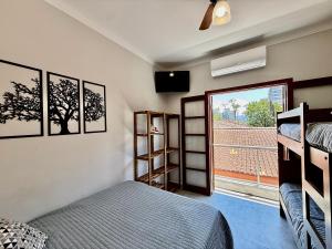 a bedroom with two bunk beds and a window at Bertioga Sobrado Piscina 90m da Praia da Enseada in Bertioga +30 photos