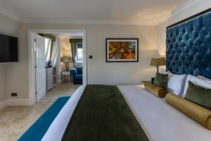 een slaapkamer met een groot bed met een blauw hoofdeinde bij Best Western Abbots Barton Hotel in Canterbury +64 foto's
