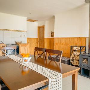 a kitchen with a wooden table and a dining room at Cabañas Rimü - Cabañas para 8 personas in Futrono +11 photos