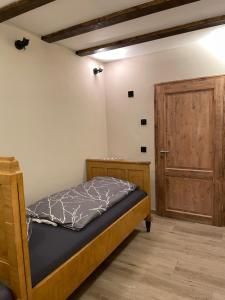 a bedroom with a bed and a wooden door at Gasthaus zur Rundkapelle in Leipzig