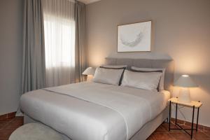a bedroom with a large white bed and a window at Monte Aria panorama suites in Herceg-Novi