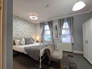 ペイントンにあるAmbassador Guest Houseのベッドルーム1室(ベッド1台、椅子、窓付)