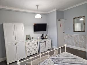 ペイントンにあるAmbassador Guest Houseのベッドルーム(ベッド1台、テレビ、ドレッサー付) +26枚の写真