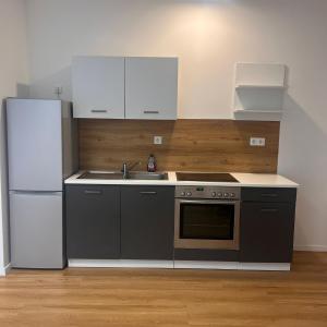 a kitchen with a refrigerator and a stove and a sink at BB Rooms in Kerpen