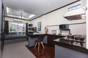 a kitchen with a sink and a counter with a chair at Beautiful apartment in Ban Thalat Choeng Thale