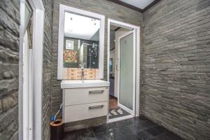 a bathroom with a sink and a mirror on a brick wall at Beautiful apartment in Ban Thalat Choeng Thale