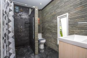 a bathroom with a shower and a toilet and a sink at Beautiful apartment in Ban Thalat Choeng Thale +4 photos