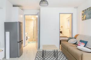 a living room with a couch and a refrigerator at Superbe appartement proche de stations de ski in Thonon-les-Bains