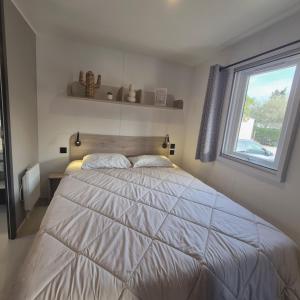 a bedroom with a large bed with a window at Le Cocon Mobil Home à 150 m de la plage Camping 5 Etoiles Les Dunes Parc Aquatique in Torreilles +36 photos