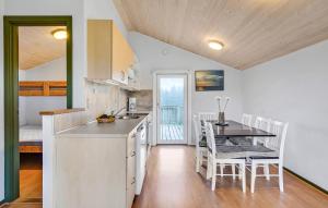 a kitchen and dining room with a table and chairs at Nice Home In Hanstholm With Private Swimming Pool, Can Be Inside Or Outside in Pugdal