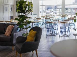 a dining room with chairs and tables and a table at ibis Styles Mt Isa Verona in Mount Isa