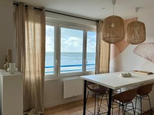 a dining room with a table and a large window at L'Entre-Deux Portelois, Sea view cocoon in Le Portel