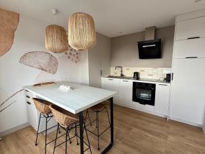 a kitchen with a table and two stools at L'Entre-Deux Portelois, Sea view cocoon in Le Portel