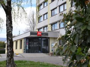 un edificio con una señal roja delante de él en ibis Chambery, en Chambéry