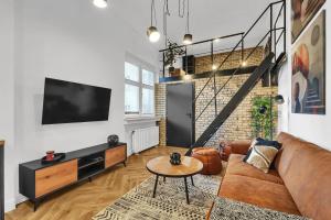 a living room with a couch and a tv at Central Designer Loft - Modern & Chic in Staré Mesto