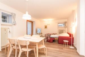 a dining room with a table and chairs and a bed at La Casa di Paola in La Thuile