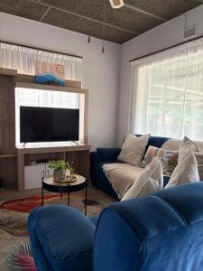 a living room with a blue couch and a tv at 33 Boeren in Vryheid