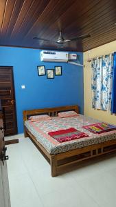 Bett in einem Zimmer mit blauer Wand in der Unterkunft Gokarna beach point rooms in Gokarn