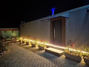 a row of benches in front of a building with lights at Casa Container Mirante do Cristo in Foz do Iguaçu