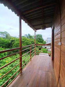 a wooden balcony with a view of the forest at Cabana La Casita Recanto dos Pássaros in Navegantes