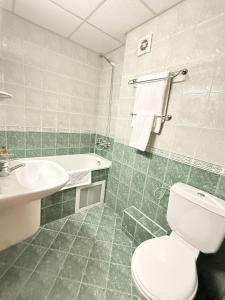 a bathroom with a white toilet and a sink at Struma Hotel in Pernik