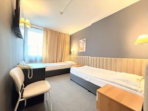 a hotel room with two beds and a chair at Struma Hotel in Pernik