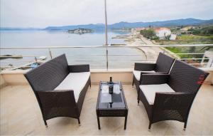 a balcony with a table and chairs and a view of the water at Gorgeous Apartment In Sreser With House Sea View in Sreser +8 photos