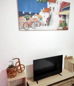 a flat screen tv sitting on a stand in a living room at Era Apartman in Harkány +51 photos
