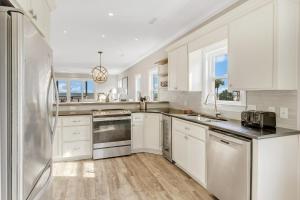 a kitchen with white cabinets and a stainless steel refrigerator at GP57: 57 Grand Pavilion in Isle of Palms
