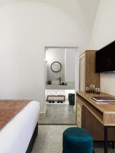 a hotel room with a bed and a desk at Astris Suite, Mansion Double Room, Imerovigli in Imerovigli