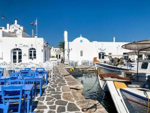 a group of blue chairs and boats in a harbor at Astris Suite, Mansion Double Room, Imerovigli in Imerovigli