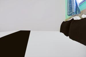 a bedroom with a bed with black pillows at Hotel O Galaxy Stay in Chandrapur