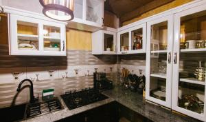 a kitchen with white cabinets and a sink at THE WOODEN HOUSE in Moshi