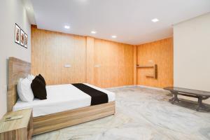 a bedroom with a bed and a desk in it at Hotel O P2 in Bhopal