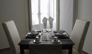a dining room table with chairs and a black table with glasses at B&B Il Ritratto in Salerno