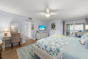 a bedroom with a bed and a dresser and a desk at Island Beach Club 210E in Sanibel +46 photos