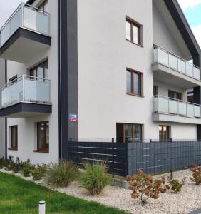 an apartment building with balconies and a yard at Apartament Zefir in Busko-Zdrój