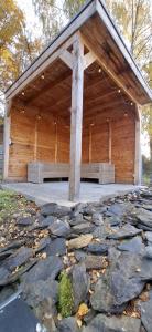 a large wooden building with a roof on rocks at Chez Ellen in Tavigny